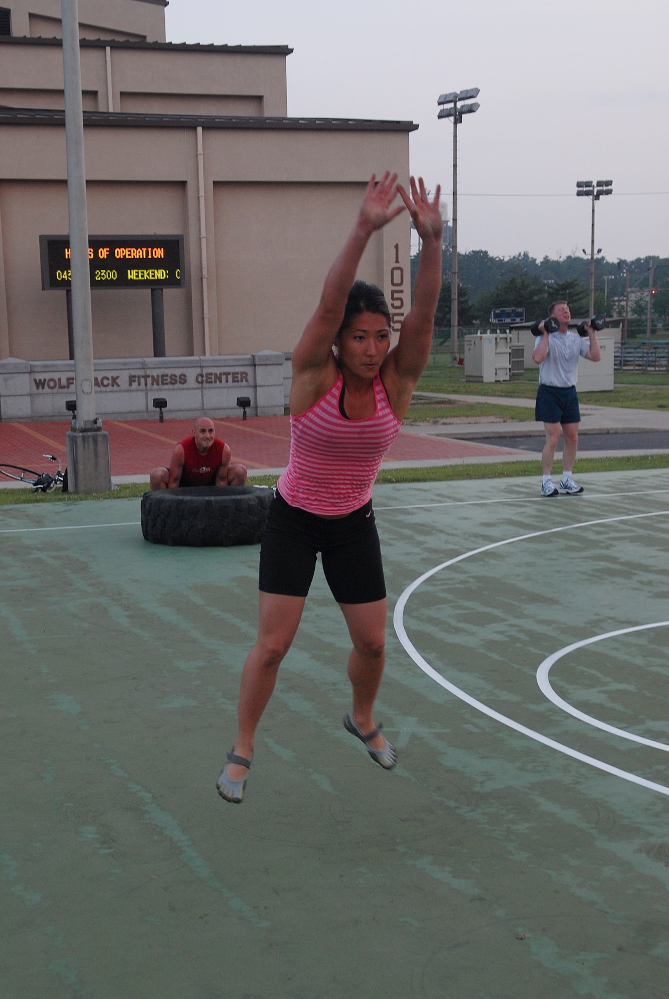 KUNSAN AIR BASE, Republic of Korea -- Capt. Christine Knieff, 8th Maintenance Group, jumps; Capt. Jason Leblanc, a visiting 7th Air Force member, flips a tire; and Col. John Dolan, 8th Fighter Wing commander, lifts dumbbells during a CrossFit workout July 27. CrossFit's purpose is to move large loads over long distances, quickly. (U.S. Air Force photo/Senior Airman Roy Lynch)