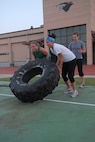 KUNSAN AIR BASE, Republic of Korea -- Capt. Melissa Thurman, 8th Fighter Wing, and 1st Lt. Fiona Dailey, 8th Fighter Wing, flip a tire, while 1st Lt. Kari Kundert, 8th Operation Group, keeps watch for safety and proper form during a CrossFit workout July 27. CrossFit combines aerobic workouts with strength training to increase strength, flexibility, agility and endurance. (U.S. Air Force photo/Senior Airman Roy Lynch)