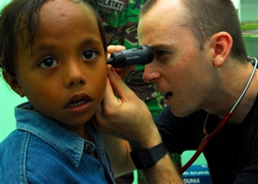 U.S. Navy Lt. Timothy Chinnock, a doctor assigned to the Military Sealift Command hospital ship USNS Mercy (T-AH 19), examines a child’s ear during a medical civic action program in Tidore, Indonesia, on July 20, 2010.  The Mercy is in the North Maluku province of Indonesia conducting Pacific Partnership 2010, the fifth in a series of annual U.S. Pacific Fleet missions being conducted as part of a disaster relief exercise aimed at strengthening regional partnerships.  