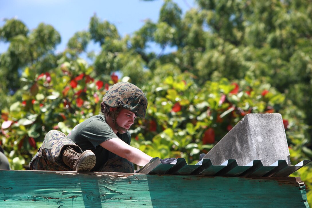 U.S. Marine Cpl. Crystal Person, 2nd Marine Logistics Group, supply battalion, attached to Special-Purpose Marine Air-Ground Task Force Continuing Promise 2010, nails sheet metal on a hospital roof in Port-de Paix, Haiti, on the morning of July 29. CP10 is a collaborative effort that involves military and civilian personnel providing humanitarian assistance and disaster relief to the Caribbean, Central and South America.