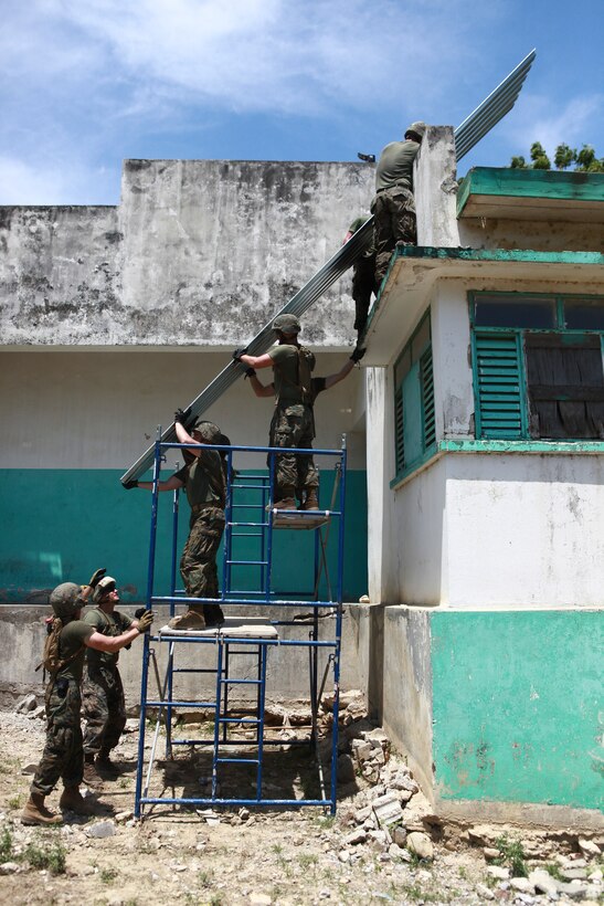 U.S. Marines with 8th Engineer Support Battalion, Logistics Combat Element of Special-Purpose Marine Air-Ground Task Force Continuing Promise 2010, work together to lift sheet metal to a hospital roof in Port-de Paix, Haiti, on the morning of July 29. CP10 is a collaborative effort that involves military and civilian personnel providing humanitarian assistance and disaster relief to the Caribbean, Central and South America.