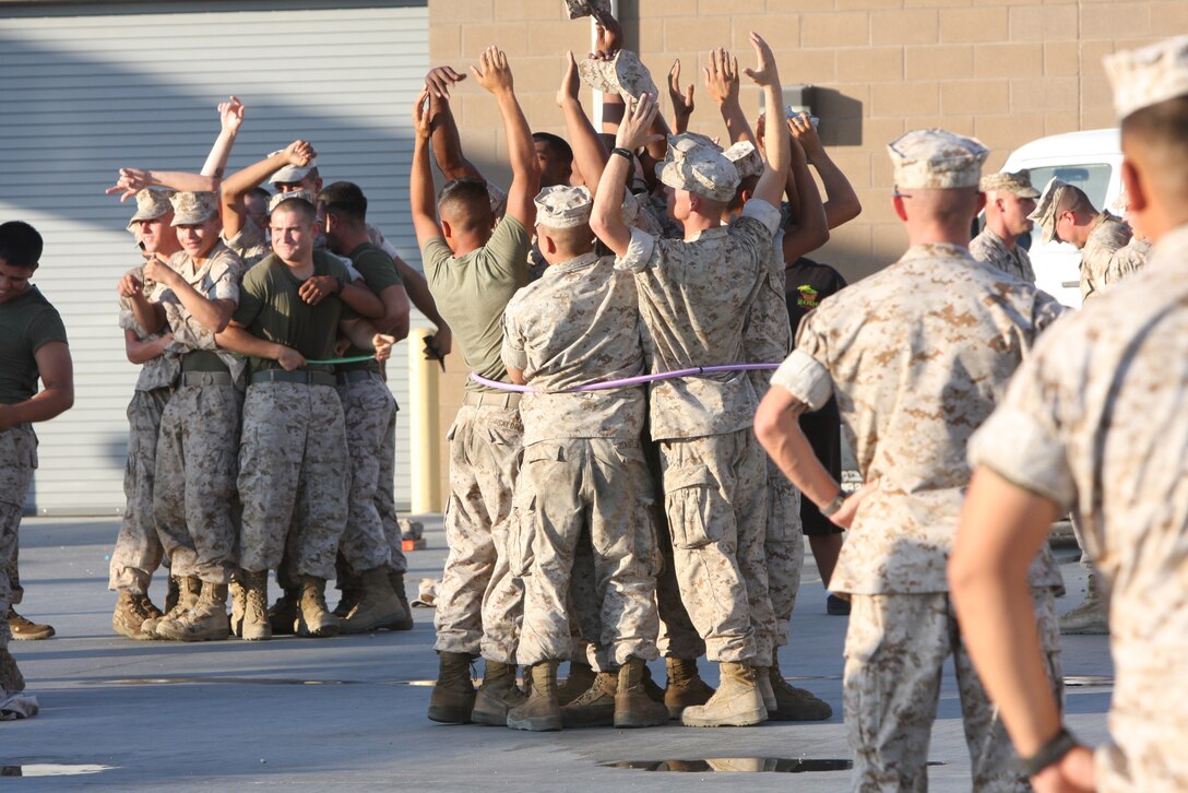 MARINE CORPS AIR GROUND COMBAT CENTER TWENTYNINE PALMS, Calif.--Marines from the 3rd Light Armored Calvary Battalion see how many Marines they can fit into a hool-a-hoop during the Barracks Bash July 29 at the 3rd LAR ramp. The bash was hosted by the Single Marines Program.