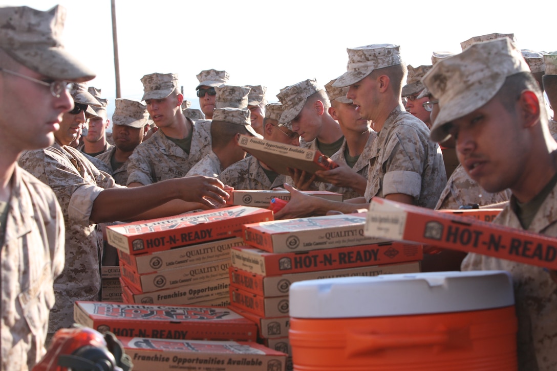 MARINE CORPS AIR GROUND COMBAT CENTER TWENTYNINE PALMS, Calif.--Marines from the 3rd Light Armored Calvary Battalion grab their dinner during a Barracks Bash July 29 at the 3rd LAR ramp. The stack of 300 pizzas, provided by the Single Marines Program, was gone in less than ten minutes.