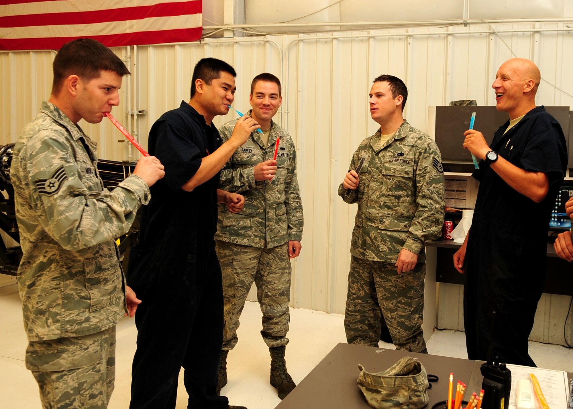 (From left) Staff Sgt. Nathaniel Monica, Airmen 1st Class Gian Anacleto and Joseph Farley, Staff Sgt. David Hink, and Tech. Sgt. Dan Naef, all members of the 355th Equipment Maintenance Squadron, cool off in their flight-line hangar and enjoy some popsicles donated by the Military Affairs Committee and distributed July 28, 2010. "I really appreciate it," said Airman 1st Class Christopher Scobey, a 355th EMS crew chief. "It's really nice to know that someone has us in mind while we're out here working in the heat." The MAC intends to make the popsicle giveaways a regular event here at D-M. (U.S. Air Force photo/Airman 1st Class Jerilyn Quintanilla)

