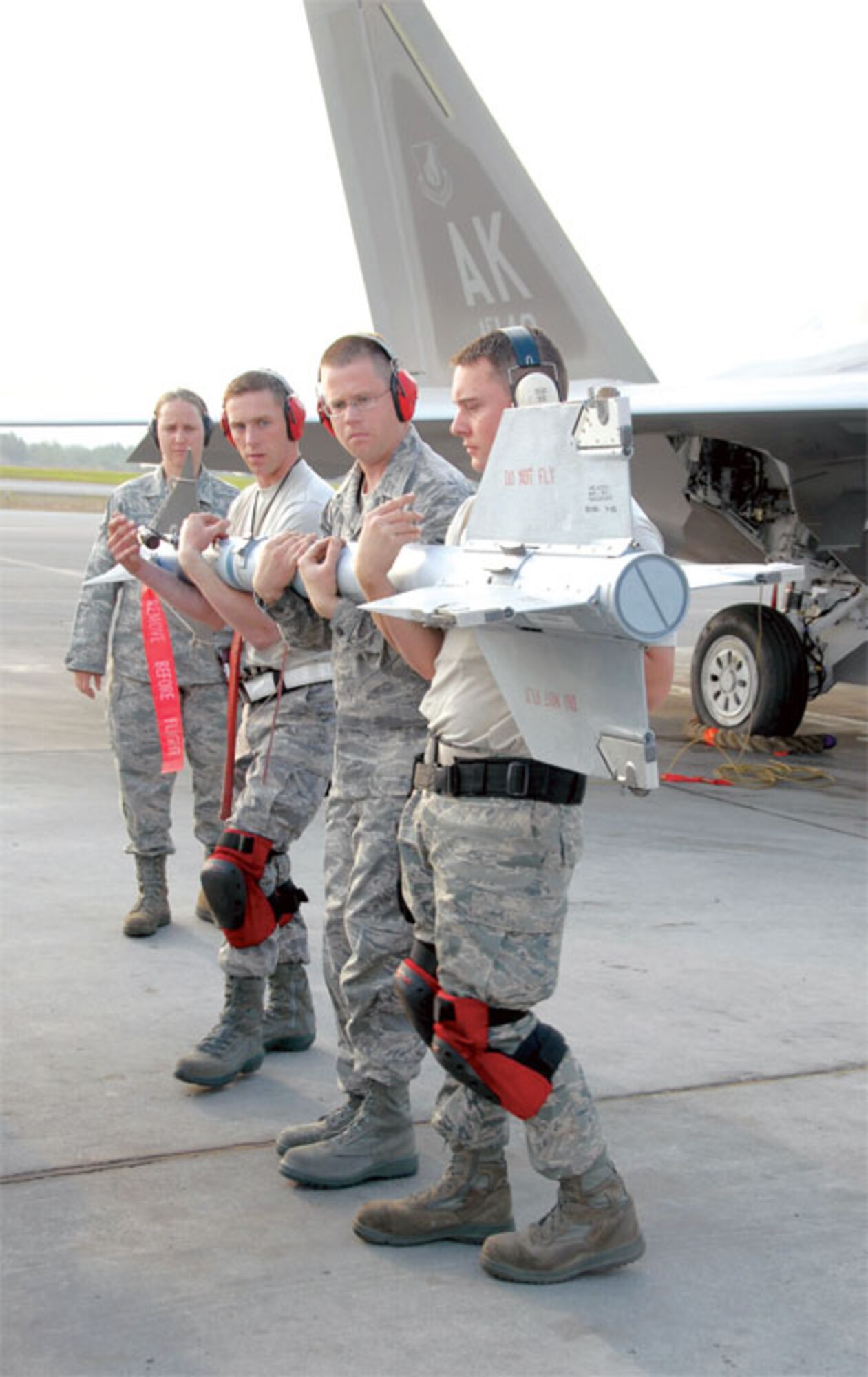 Tech Sgts. Bishop Bailey and Michael Mitchell and Air Force Staff Sgt. Nick Barnes from the 477th Fighter Group Aircraft Maintenance Squadron carry an AIM-9 to load on an F-22A Raptor during the 3rd Wing’s Load Crew Competition July 10, 2009. 
(U.S.Air Force Photo/Maj. Cary McPartlin) 