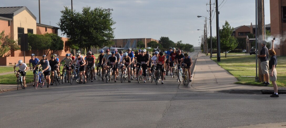 Participants mount their bikes and begin their first lap of the mini-biathlon on a designated path through Sheppard Air Force Base, Texas, July 24.  The biathlon consisted of a 20K bike ride and a 5K run through the base. The winners were selected based on the three fastest times in the categories of men 40 and over, men 39 and under, women 39 and under, youth boys 16 and under and youth girls 16 and under. (U.S. Air Force photo/Airman 1st Class Adawn Kelsey) 