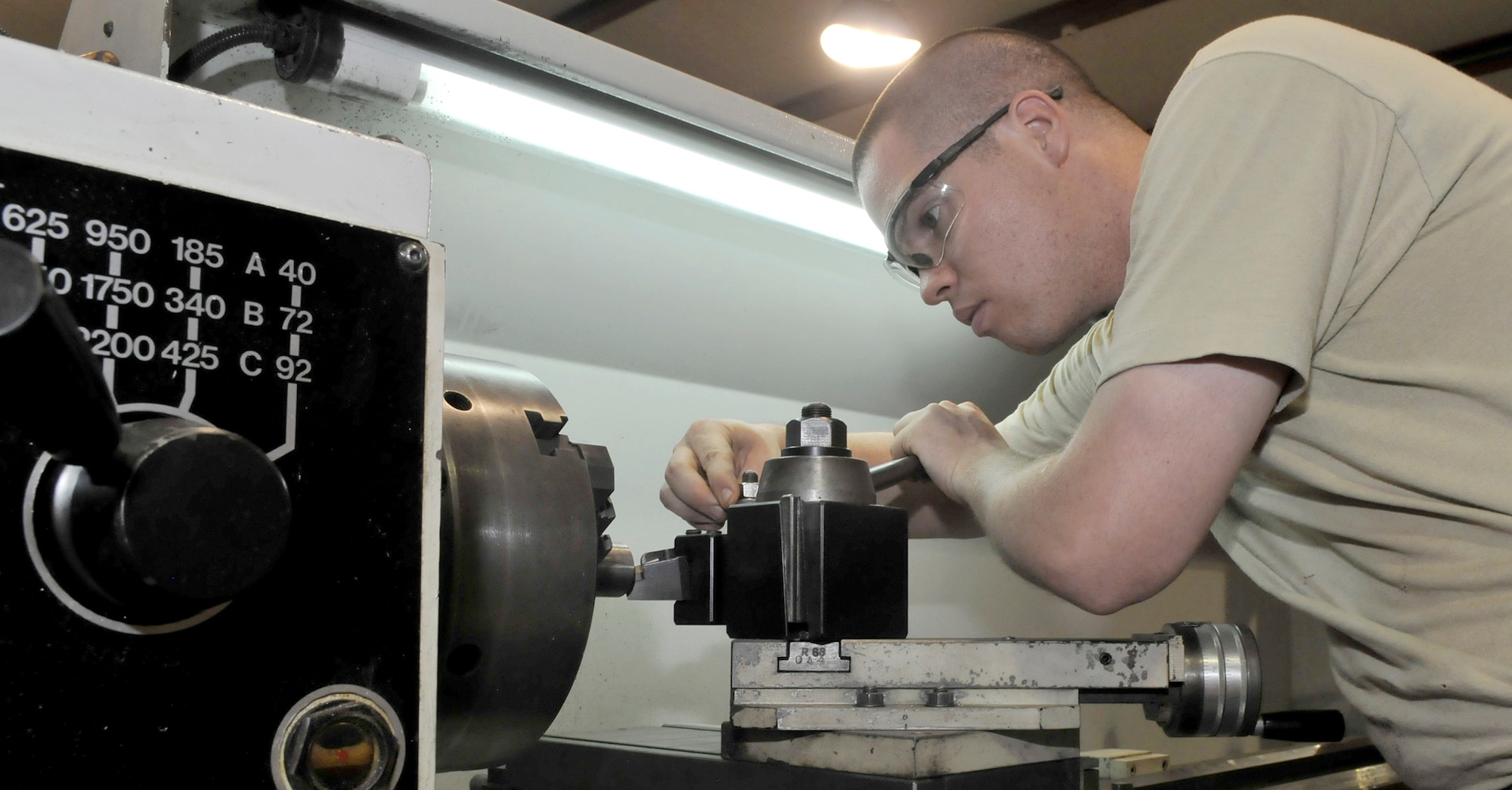 Staff Sgt. Bradley White aligns a cutting die on a metal lathe before turning replacement alignment pins for an emergency aircraft landing gear arrest system July 21, 2010, at Joint Base Balad, Iraq. Sergeant White is a 332nd Maintenance Squadron metals technology craftsman (U.S. Air Force photo/ Staff Sgt. Phillip Butterfield) 