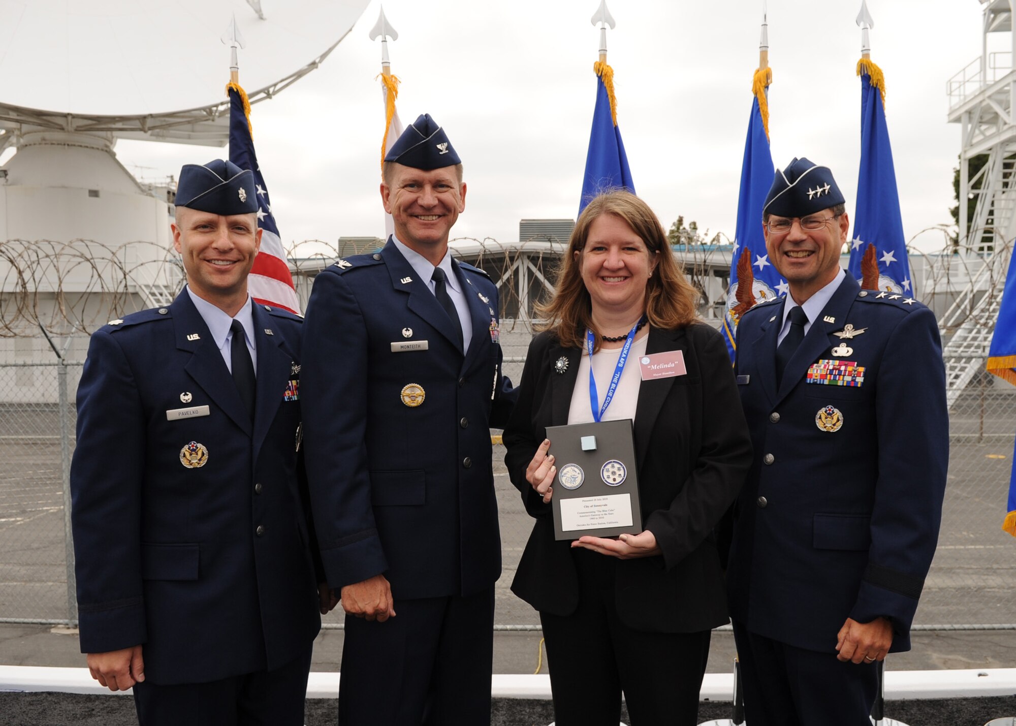 SUNNYVALE, Calif.-- Lt. Gen. John T. Sheridan, commander of the Space and Missile Center, Los Angeles Air Force Base, Col. Wayne Monteith, the 50th Space Wing commander, and Lt. Col. Robert Pavelko, 21st Space Operations Squadron commander, present a commemorative plaque to Mayor Melinda Hamilton here, Wednesday, July 28, 2010. Built in 1960, Onizuka AFS was originally known as the Air Force Satellite Test Center. It was selected for closure by the Base Closure and Realignment Commission in 2005, with the recommendation to move operations to Vandenberg Air Force Base, in order to consolidate satellite command and control operations while reducing excess infrastructure.  (U.S. Air Force Photo/Senior Airman Bryan Boyette)