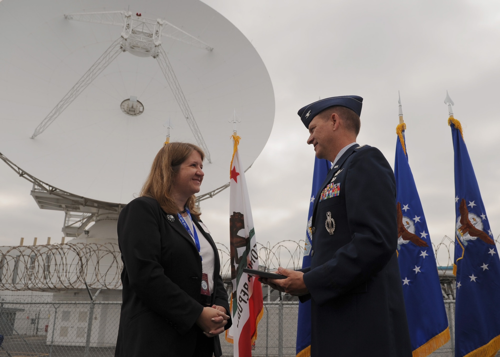 SUNNYVALE, Calif.-- Col. Wayne Monteith, the 50th Space Wing commander, presents a commemorative plaque to Mayor Melinda Hamilton during the Onizuka Air Force Station closure ceremony here, Wednesday, July 28, 2010. Built in 1960, Onizuka AFS was originally known as the Air Force Satellite Test Center. It was selected for closure by the Base Closure and Realignment Commission in 2005, with the recommendation to move operations to Vandenberg Air Force Base, in order to consolidate satellite command and control operations while reducing excess infrastructure. (U.S. Air Force Photo/Senior Airman Bryan Boyette)