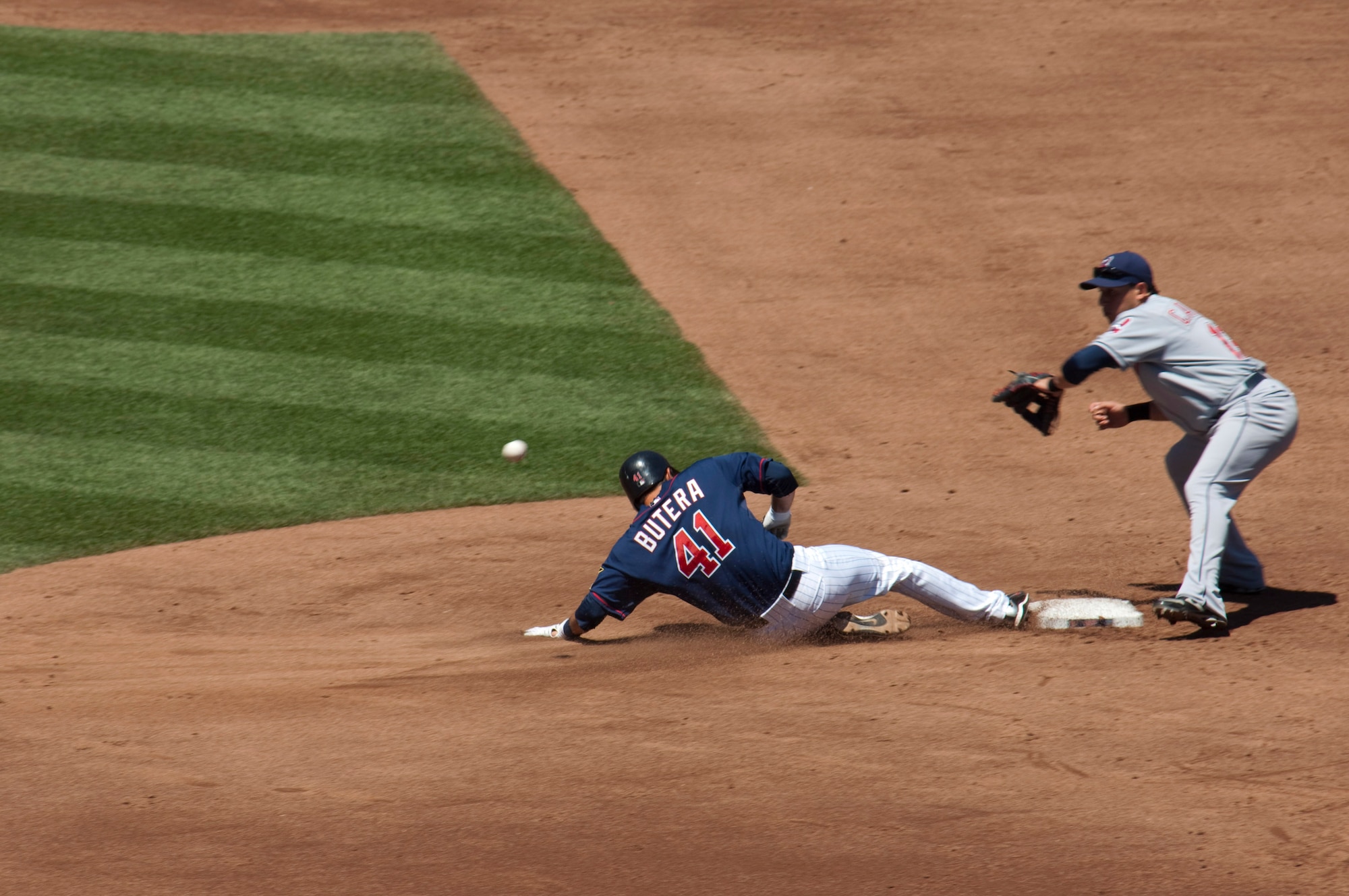 Minnesota Twins catcher Drew Butera slides into second base ahead of the ball in the third inning, starting a rally that takes the Twins to a 6-0 victory over the Cleveland Indians at Target Field in front of 40,799 fans on July 21, 2010 as the Twins celebrated ties with the military community with Navy Day. At the beginning of the game, a Minnesota Air National Guard C-130 dropped the U. S. Navy "Leap Frogs" parachute team onto Target Field. USAF official photo by Senior Master Sgt. Mark Moss