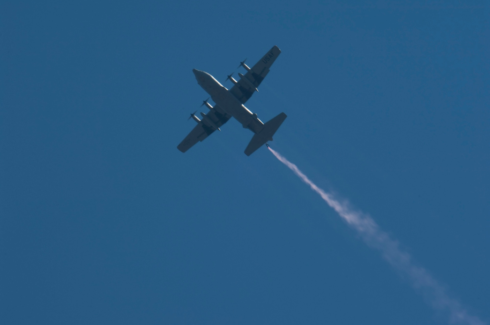 A sailor with the U. S. Navy parachute team "Leap Frogs" trails smoke as he hangs off the end of the ramp of a C-130 "Hercules" from the 133rd Airlift Wing, Minnesota Air National Guard flying over Target Field and downtown Minneapolis on July 21, 2010. The Minnesota Twins are celebrating Navy Day in their new stadium. The Air National Guard crew is joined by aviators from the 934th Airlift Wing, U. S. Air Force Reserve supporting this event.  USAF official photo by Senior Master Sgt. Mark Moss