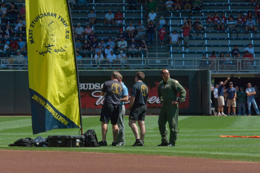 A drop zone liaison officer from the 133rd Airlift Wing, Minnesota Air National Guard and members of the U. S. Navy parachute team "Leap Frogs" prepare a landing zone next to second base at Target Field on July 21, 2010. The Minnesota Twins are celebrating Navy Day in their new stadium where the Navy "Leap Frogs" are dropped from a Minnesota Air Guard C-130 to glide into Target Field at the opening of a Twins game. USAF official photo by Senior Master Sgt. Mark Moss