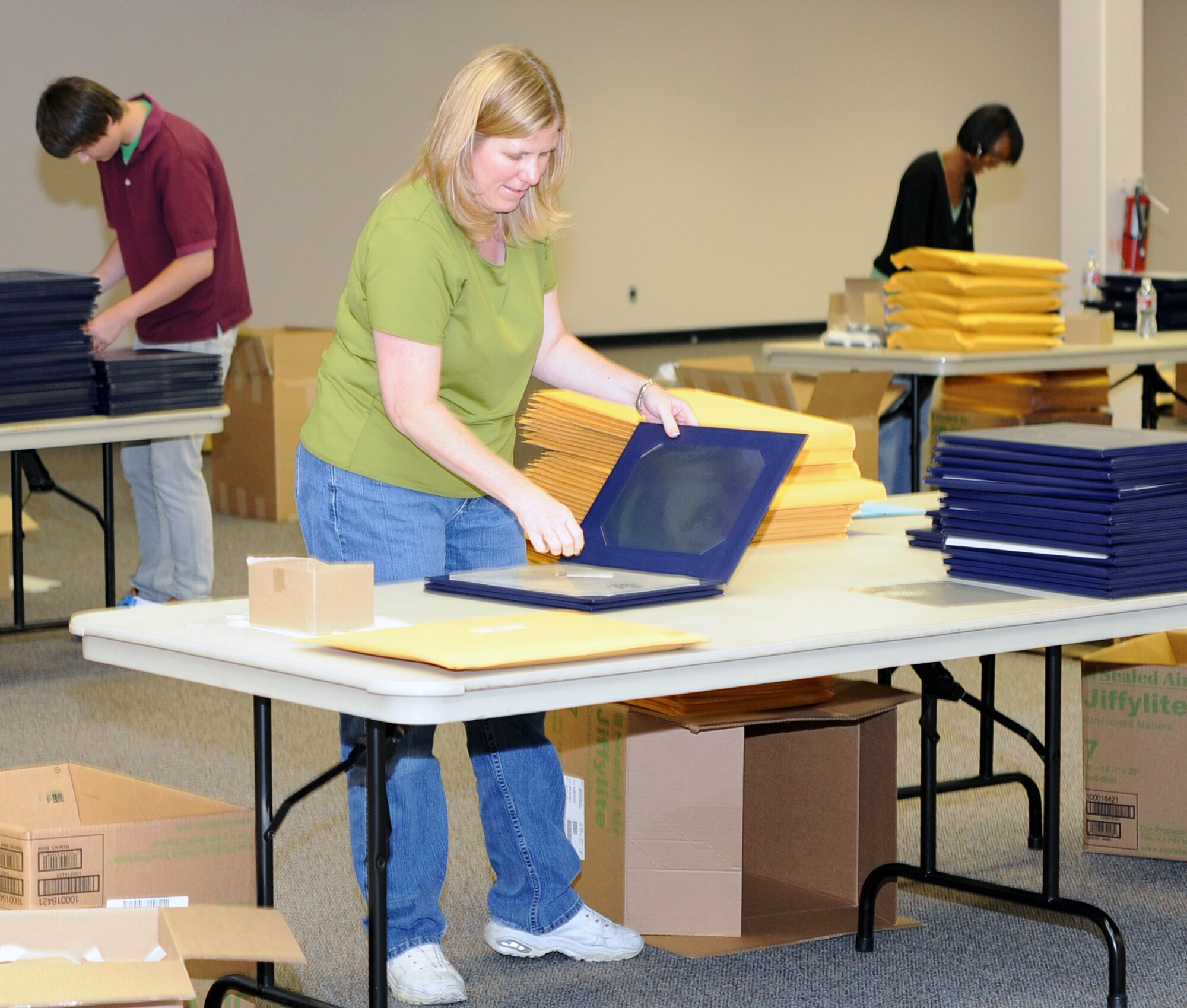 Kristy Thurman prepares a retirement certificate binder at the Air Reserve Personnel Center. On July 26, the Directorate of Personnel Service's Outbound Service Team prepared and sent more than 800 retirement ceremony packages to Airmen nationwide. (U.S. Air Force photo/Kevin Bell)