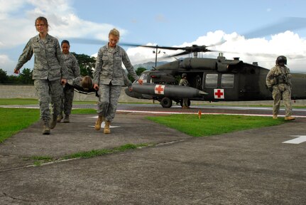 SOTO CANO AIR BASE, Honduras --  Capt. Denise Hamilton (left), Tech. Sgt. Diora Farrar, 1st Lt. Carly Fraser and Tech. Sgt. Kathy Pate (behind Lieutenant Fraser), all with the Medical Element here, carry a "patient" from a medical evacuation helicopter during a HOT/COLD aircraft loading class here July 27. Groups of medics took turns loading and unloading people onto and off of the helicopter. (U.S. Air Force photo/Tech. Sgt. Benjamin Rojek)
