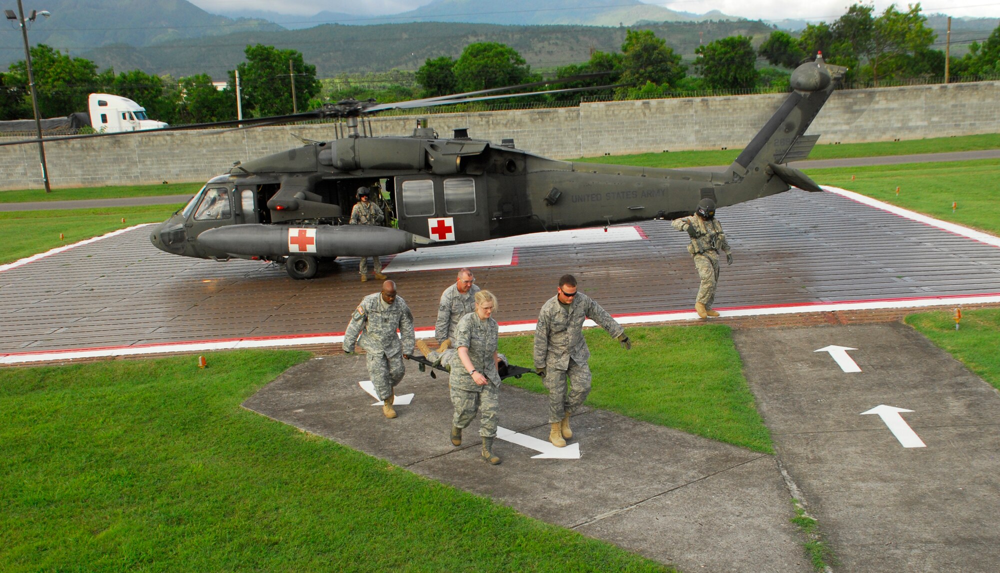 SOTO CANO AIR BASE, Honduras --  With the wind at their backs, Master Sgt. Sean Gathers, left, Tech. Sgt. Jeffrey Gray, Senior Airman Megan Wharton and Staff Sgt. Travis Smith and , all of the Medical Element here, carry a "patient" from a medical evacuation helicopter here July 27. The MEDEL conducted a HOT/COLD aircraft loading class to ensure all personnel are trained to evacuate a patient regardless of the time of day. (U.S. Air Force photo/Tech. Sgt. Benjamin Rojek)
