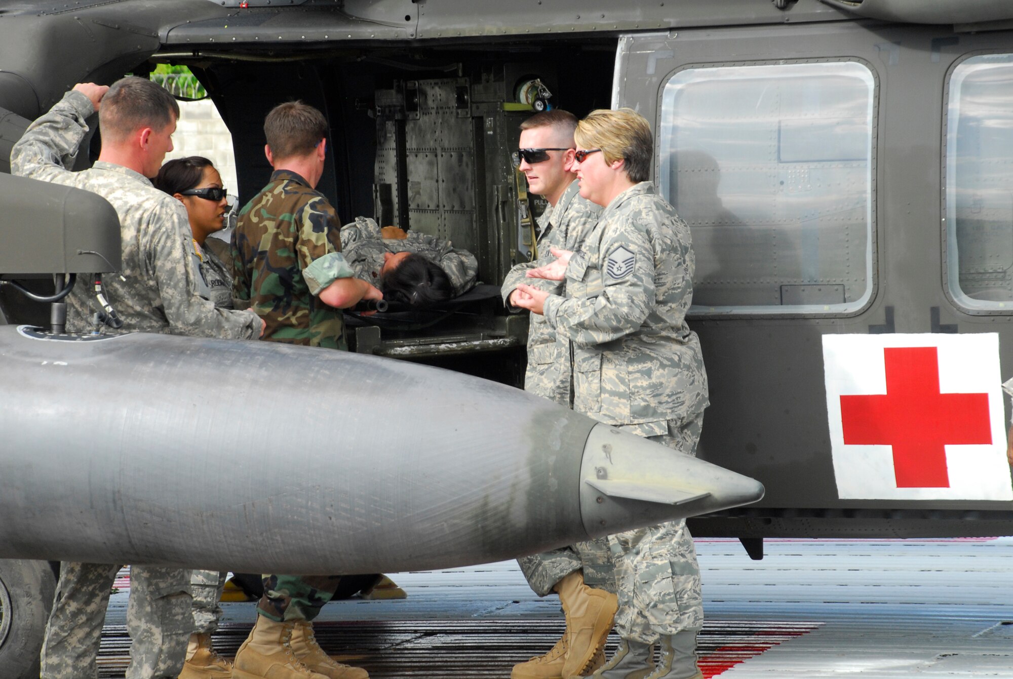SOTO CANO AIR BASE, Honduras --  A 1-228th Aviation Regiment crew chief goes over loading and unloading with Medical Element personnel procedures during a HOT/COLD aircraft loading class July 27 here. The main purpose of the training is to ensure all personnel are trained to evacuate a patient regardless of the time of day. (U.S. Air Force photo/Tech. Sgt. Benjamin Rojek)

