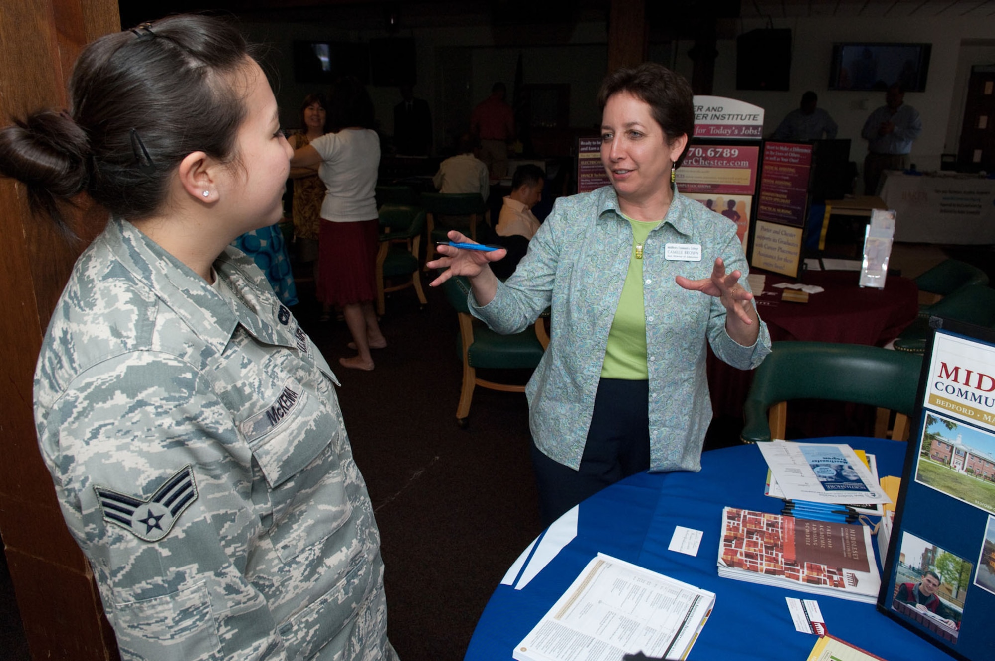 HANSCOM AIR FORCE BASE, Mass. -- Senior Airman Christina McKenna learns about Middlesex Community College from Camille Brown, assistant director of admissions, during the Education Fair at the Minuteman Club on July 22. (U.S. Air Force photo by Rick Berry)