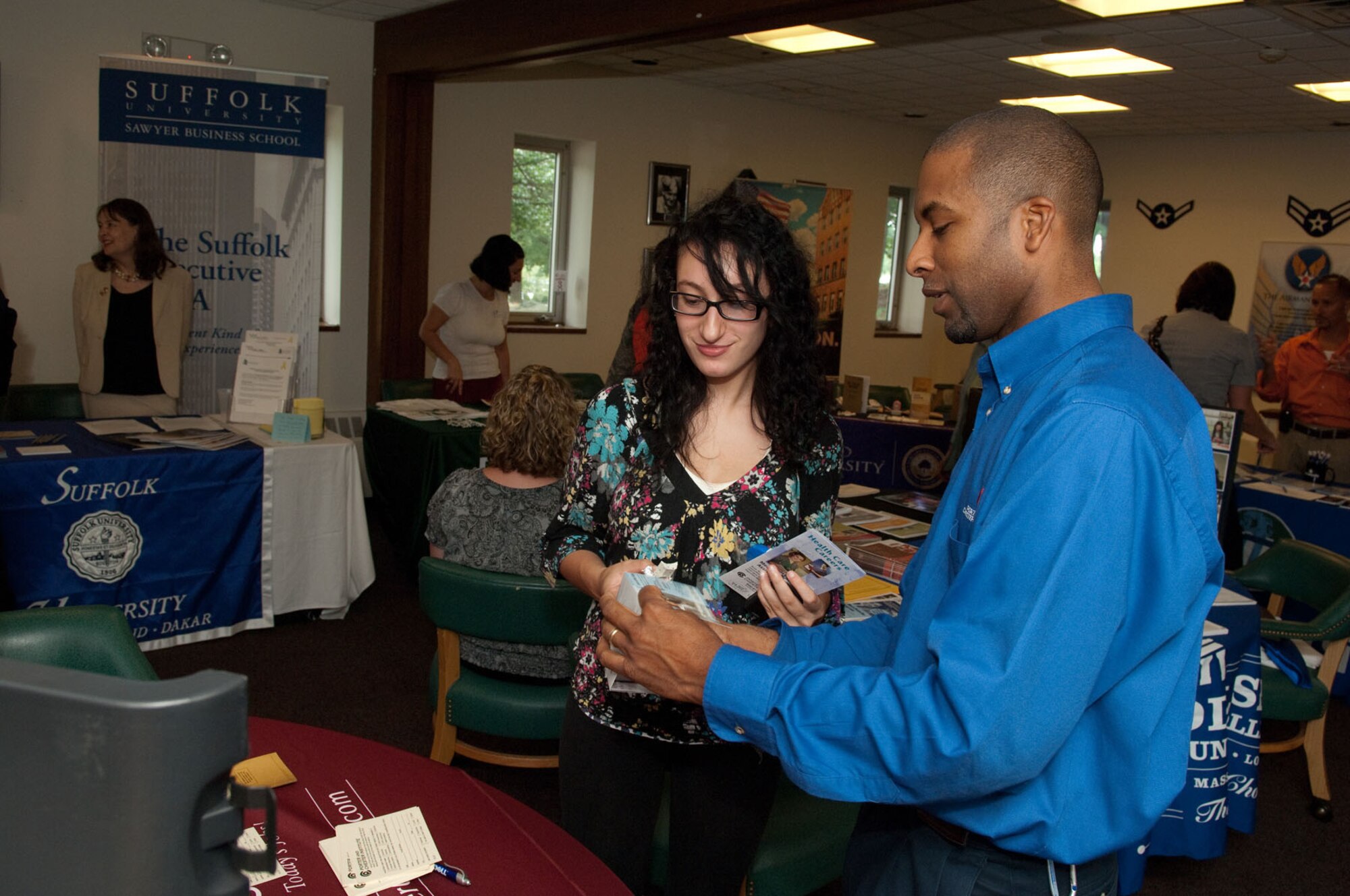 HANSCOM AIR FORCE BASE, Mass. -- Ariane Levensan (left) speaks with Jon Dyer from Porter and Chester Institute during the Education Fair at the Minuteman Club on July 22. (U.S. Air Force photo by Rick Berry)