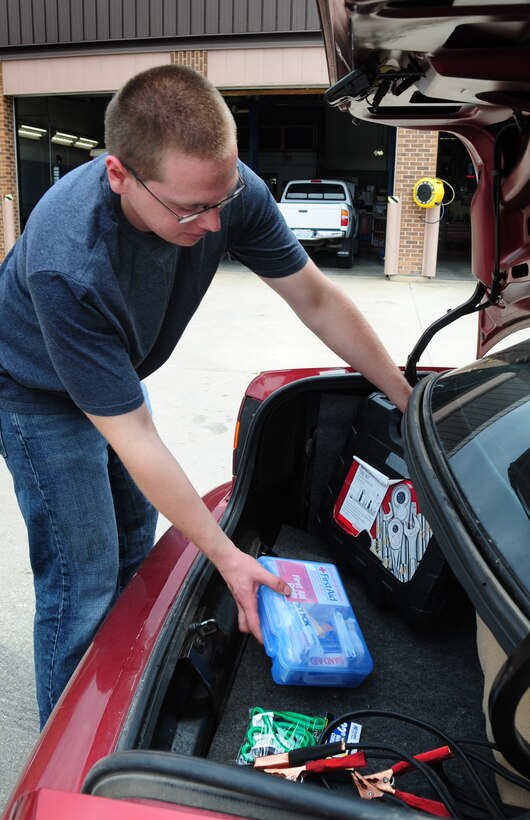 ELLSWORTH AIR FORCE BASE, S.D. -- Airman 1st Class Joshua Dunn, 28th Logistics Readiness Squadron vehicle maintainer, stows a tool kit and a first-aid kit in the truck of his car, July 28.  Items like a tool kit, first-aid kit and jumper cables should be kept in the car for emergency situations. (U.S. Air Force photo/Airman 1st Class Anthony Sanchelli)