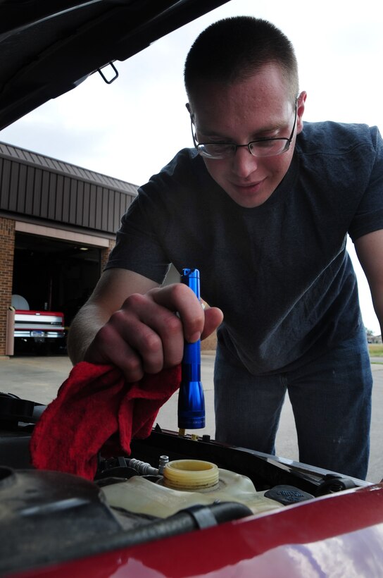 ELLSWORTH AIR FORCE BASE, S.D. -- Airman 1st Class Joshua Dunn, 28th Logistics Readiness Squadron vehicle maintainer, checks the engine coolant in his car, July 28.  Without coolant the engine could over-heat and ruin the engine. (U.S. Air Force photo/Airman 1st Class Anthony Sanchelli)