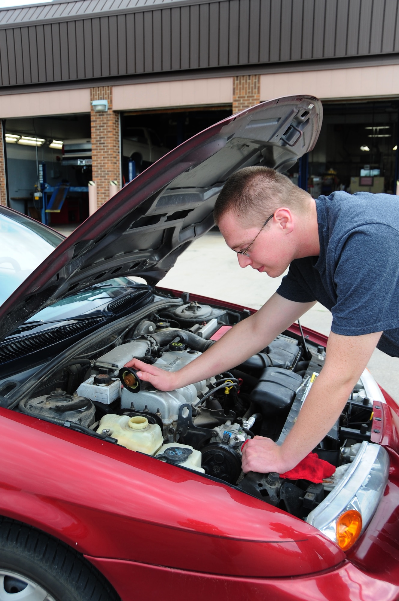 ELLSWORTH AIR FORCE BASE, S.D. -- Airman 1st Class Joshua Dunn, 28th Logistics Readiness Squadron vehicle maintainer, checks the engine coolant in his car, July 28.  The coolant keeps the engine from over-heating and potentially ruining the engine entirely. (U.S. Air Force photo/Airman 1st Class Anthony Sanchelli)