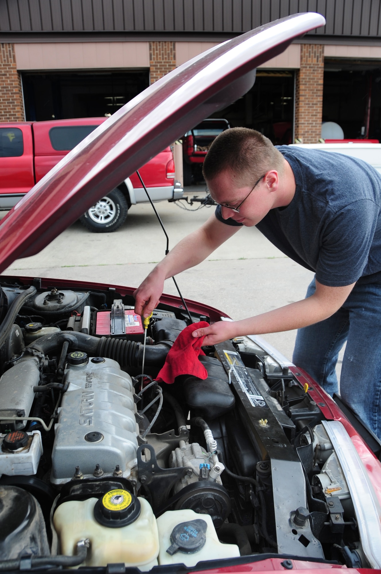 ELLSWORTH AIR FORCE BASE, S.D. -- Airman 1st Class Joshua Dunn, 28th Logistics Readiness Squadron vehicle maintainer, pulls the dip-stick out of his engine to check the oil, July 28.  It's important to check all engine fluids periodically to ensure peak performance of the engine. (U.S. Air Force photo/Airman 1st Class Anthony Sanchelli)