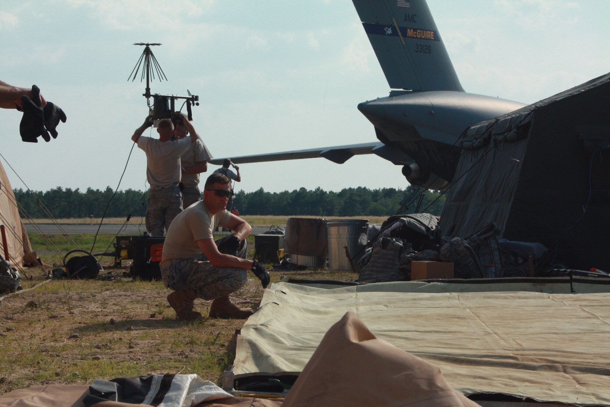 Chaplain James Ehrman from the Kentucky Air National Guard's 123rd Contingency Response Group based out of Louisville, Ky., takes a quick break while assembling a tent at Lakehurst Air Field at Akrab International Airport after arriving to provide humanitarian assistance to the country of Nessor July 27.
 (U.S. Army photo/Capt. Andi Hahn)(Released)