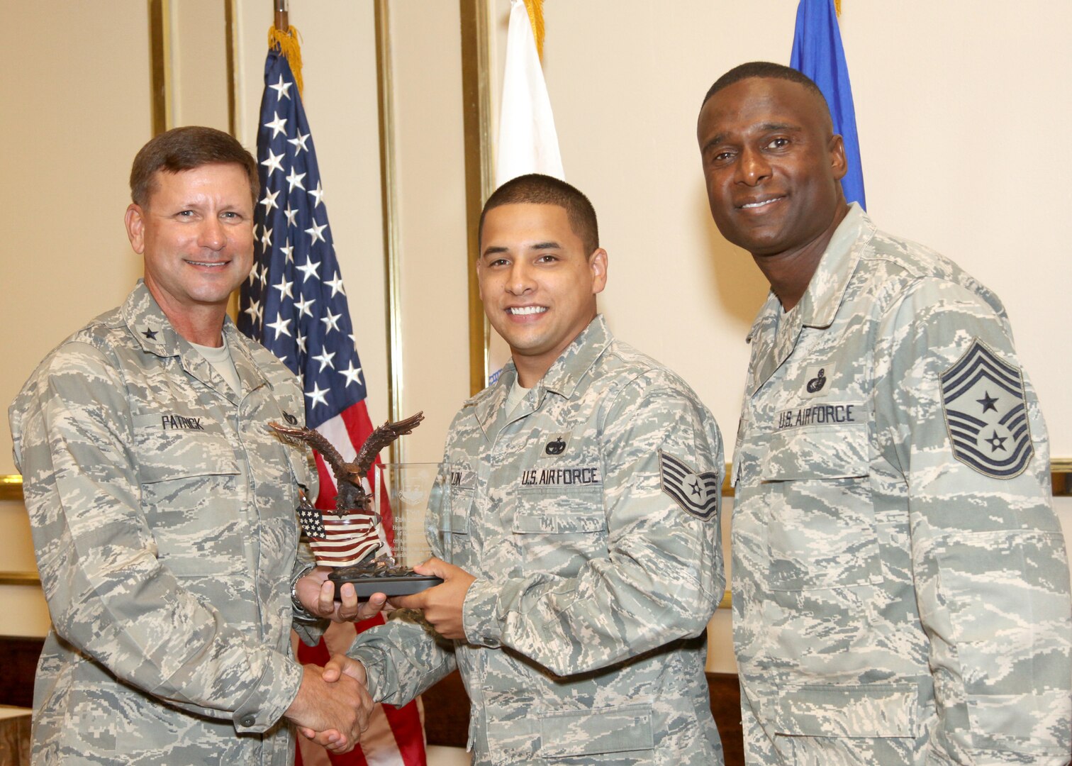 Tech. Sgt. Edwin Colon receives the NCO Honor Guard Member of the Quarter award from Brig. Gen. Leonard Patrick, 502nd Air Base Wing commander, and Chief Master Sgt. Juan Lewis, 502nd ABW command chief, during the 502nd ABW second quarter awards luncheon July 27 at the Kelly Club. Sergeant Colon is with the 345th Training Squadron. (U.S. Air Force photo/Robbin Cresswell) 