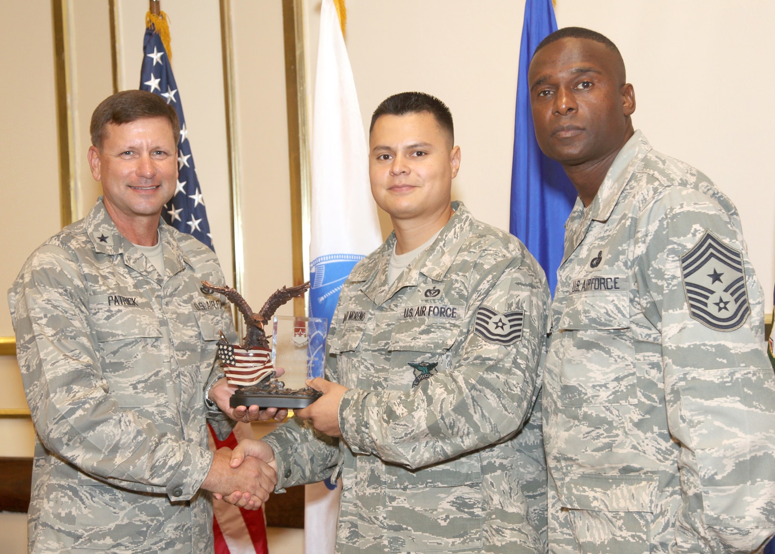 Tech. Sgt. Aguilar Moreno receives the NCO of the Quarter award from Brig. Gen. Leonard Patrick, 502nd Air Base Wing commander, and Chief Master Sgt. Juan Lewis, 502nd ABW command chief, during the 502nd ABW second quarter awards luncheon July 27 at the Kelly Club. Sergeant Moreno is with the 902nd Civil Engineer Squadron. (U.S. Air Force photo/Robbin Cresswell) 