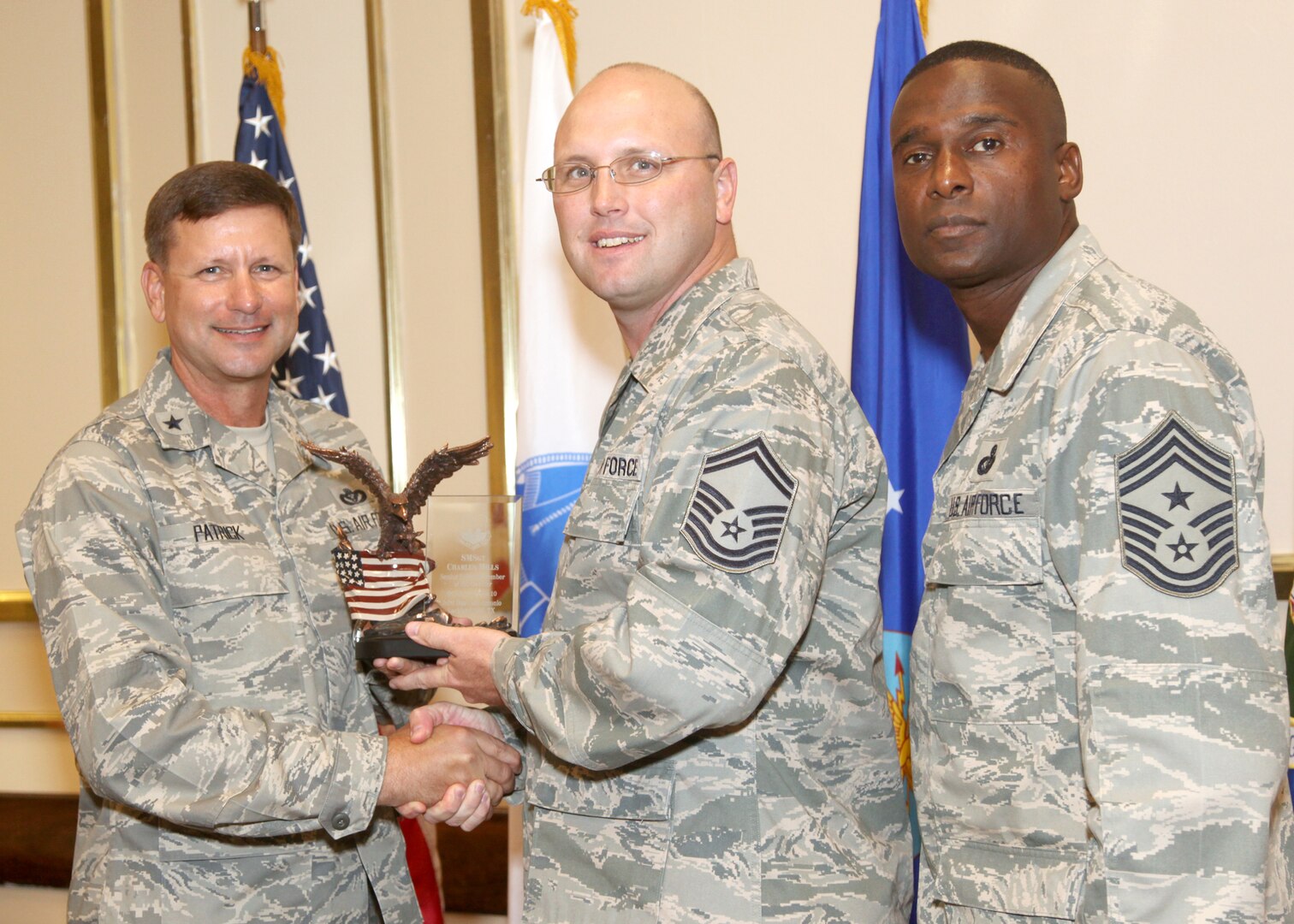 Senior Master Sgt. Charles Mills receives the Senior NCO of the Quarter award from Brig. Gen. Leonard Patrick, 502nd Air Base Wing commander, and Chief Master Sgt. Juan Lewis, 502nd ABW command chief, during the 502nd ABW second quarter awards luncheon July 27 at the Kelly Club. Sergeant Mills is with the 802nd Force Support Squadron. (U.S. Air Force photo/Robbin Cresswell)