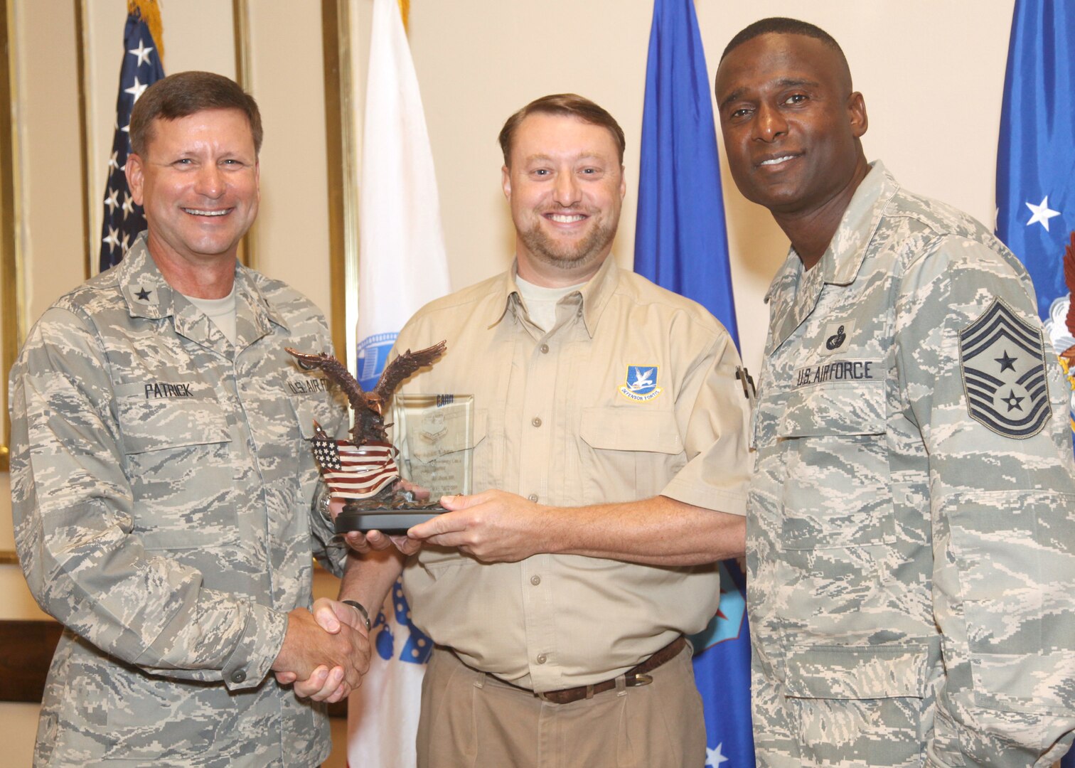 Michael Carr receives the Civilian of the Quarter Category I award from Brig. Gen. Leonard Patrick, 502nd Air Base Wing commander, and Chief Master Sgt. Juan Lewis, 502nd ABW command chief, during the 502nd ABW second quarter awards luncheon July 27 at the Kelly Club. Mr. Carr is with the 802nd Security Forces Squadron. (U.S. Air Force photo/Robbin Cresswell)