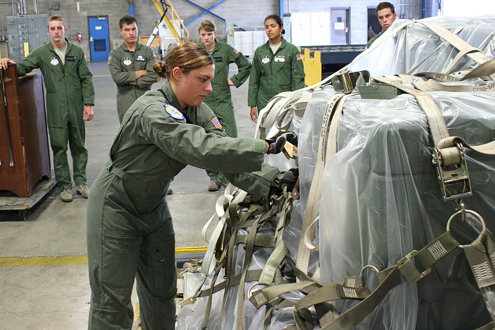 WRIGHT-PATTERSON AIR FORCE BASE, Ohio – Cadet Second Class Alexis Laleman works on building a pallet as her fellow cadets watch during their visit to the 87th Aerial Port Squadron July 24.  Cadet Laleman and six other cadets from the Air Force Academy visited the wing and the base as part of Operation Air Force, a three-week summer program through which cadets gain “real Air Force” experience during stays at Air Force bases across the country. (U.S. Air Force photo/Senior Airman Mikhail Berlin)