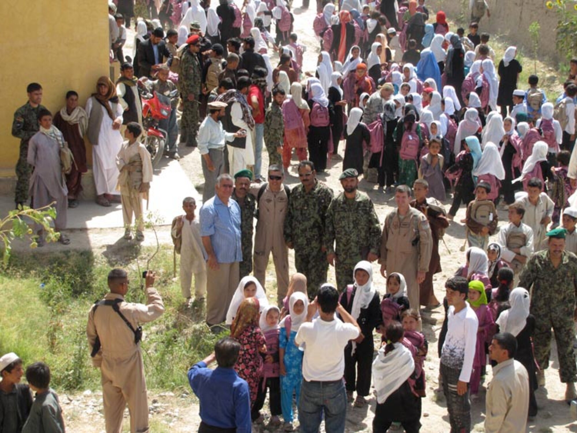 Afghan Air Force and Afghan National Army soldiers from the 209th Corps participate in their first joint Humanitarian mission distributing school supplies to children in a village outside of Mazar e Sharif, Afghanistan, on Jul. 27, 2010 (U.S. Navy photo by Mass Communications Specialist First Class Elizabeth Burke/RELEASED).