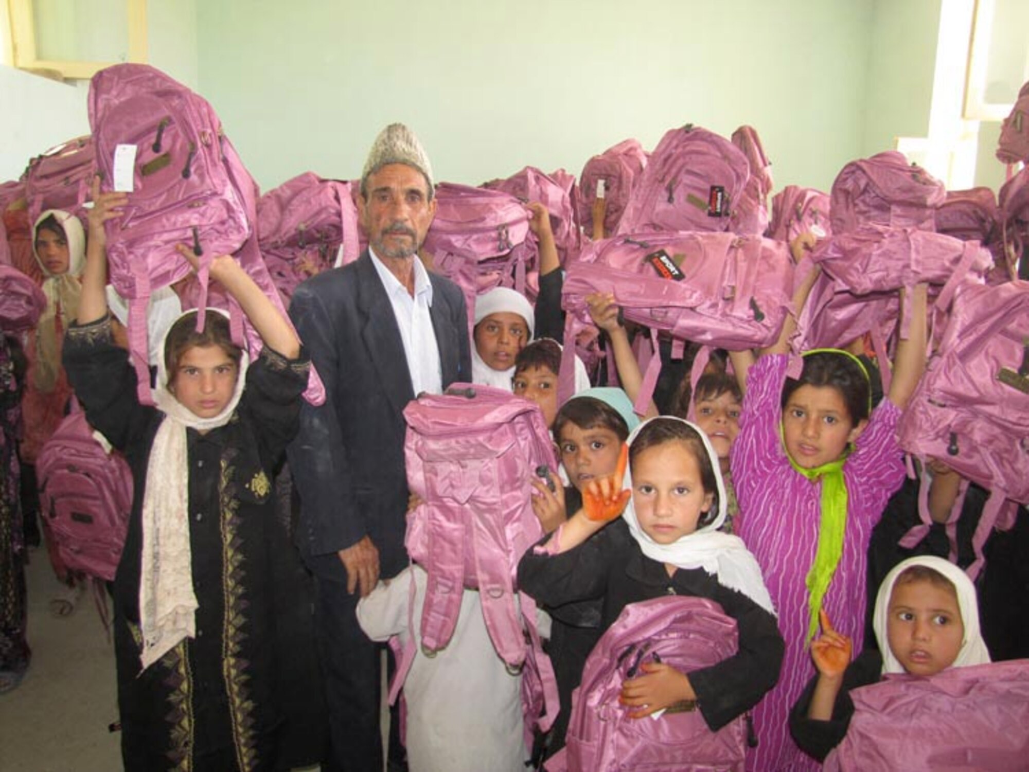 Afghan Air Force and Afghan National Army soldiers from the 209th Corps participate in their first joint Humanitarian mission distributing school supplies to children in a village outside of Mazar e Sharif, Afghanistan, on Jul. 27, 2010 (U.S. Navy photo by Mass Communications Specialist First Class Elizabeth Burke/RELEASED).