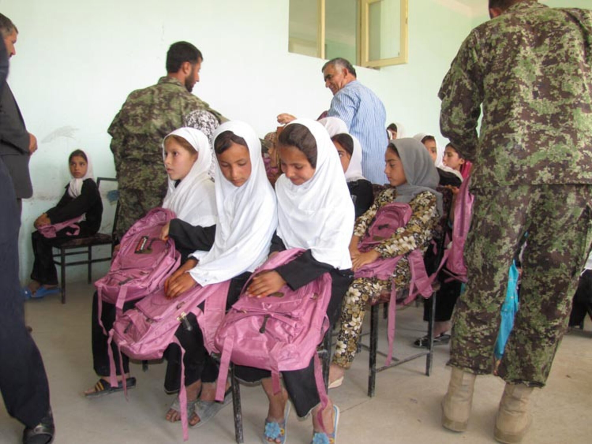 Afghan Air Force and Afghan National Army soldiers from the 209th Corps participate in their first joint Humanitarian mission distributing school supplies to children in a village outside of Mazar e Sharif, Afghanistan, on Jul. 27, 2010 (U.S. Navy photo by Mass Communications Specialist First Class Elizabeth Burke/RELEASED).