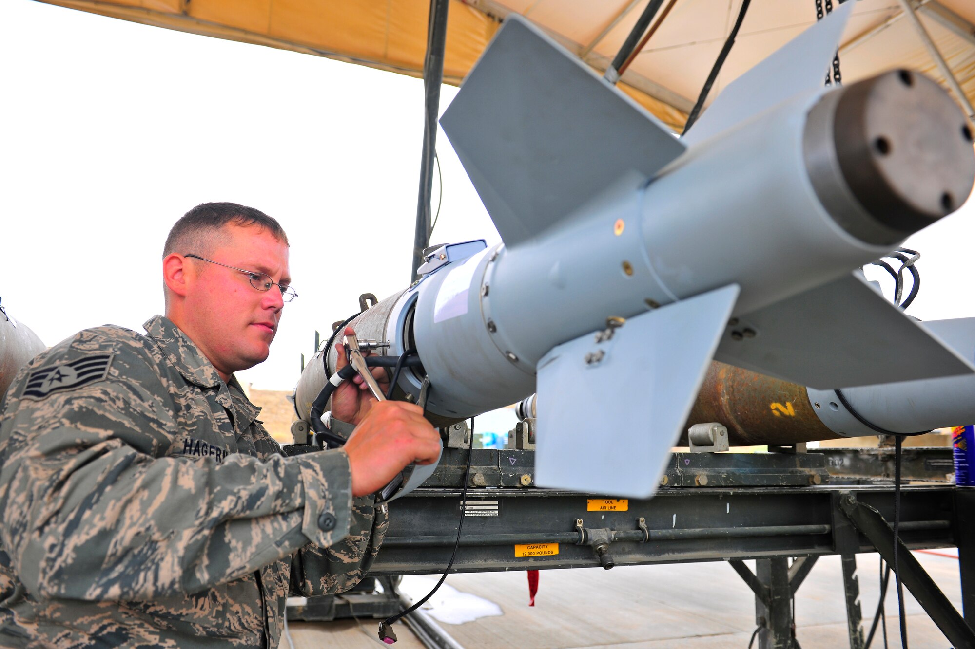 Staff Sgt. Kelley Hagerman, a munitions systems specialist assigned to the 455th Expeditionary Maintenance Squadron, attaches a tail kit to a bomb body during a bomb build at Bagram Airfield, Afghanistan, July 28, 2010. Sergeant Hagerman is a native of San Antonio, Texas. (U.S. Air Force photo/Staff Sgt. Christopher Boitz)