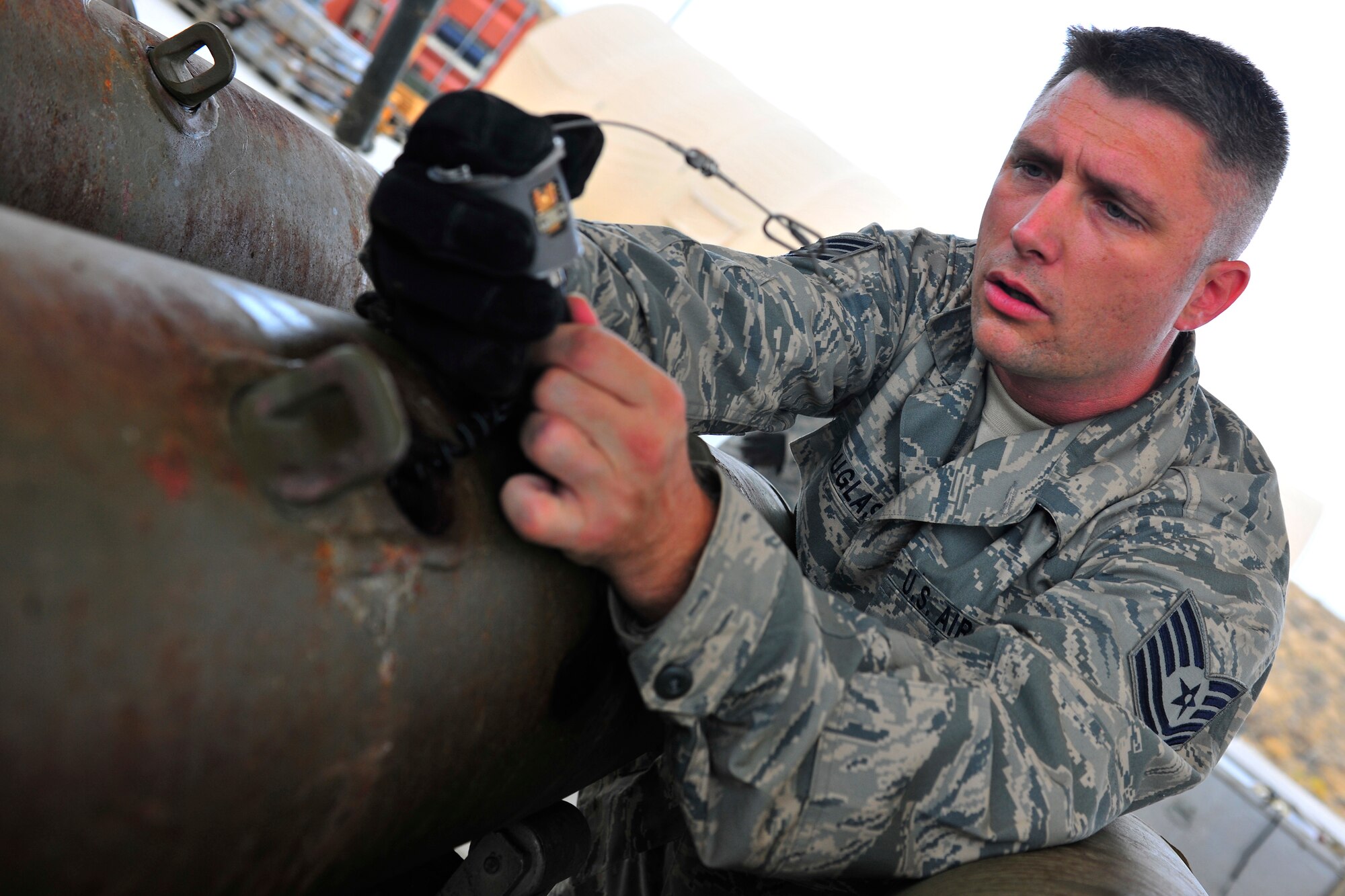 Tech. Sgt. Brian Douglas, a munitions systems specialist assigned to the 455th Expeditionary Maintenance Squadron, inserts a generator into a bomb body during a bomb build at Bagram Airfield, Afghanistan, July 28, 2010. When the bomb is dropped from an aircraft, the air flowing against the generator helps create power to arm the fuse. Sergeant Douglas is a native of Sanford, N.C. (U.S. Air Force photo/Staff Sgt. Christopher Boitz)
