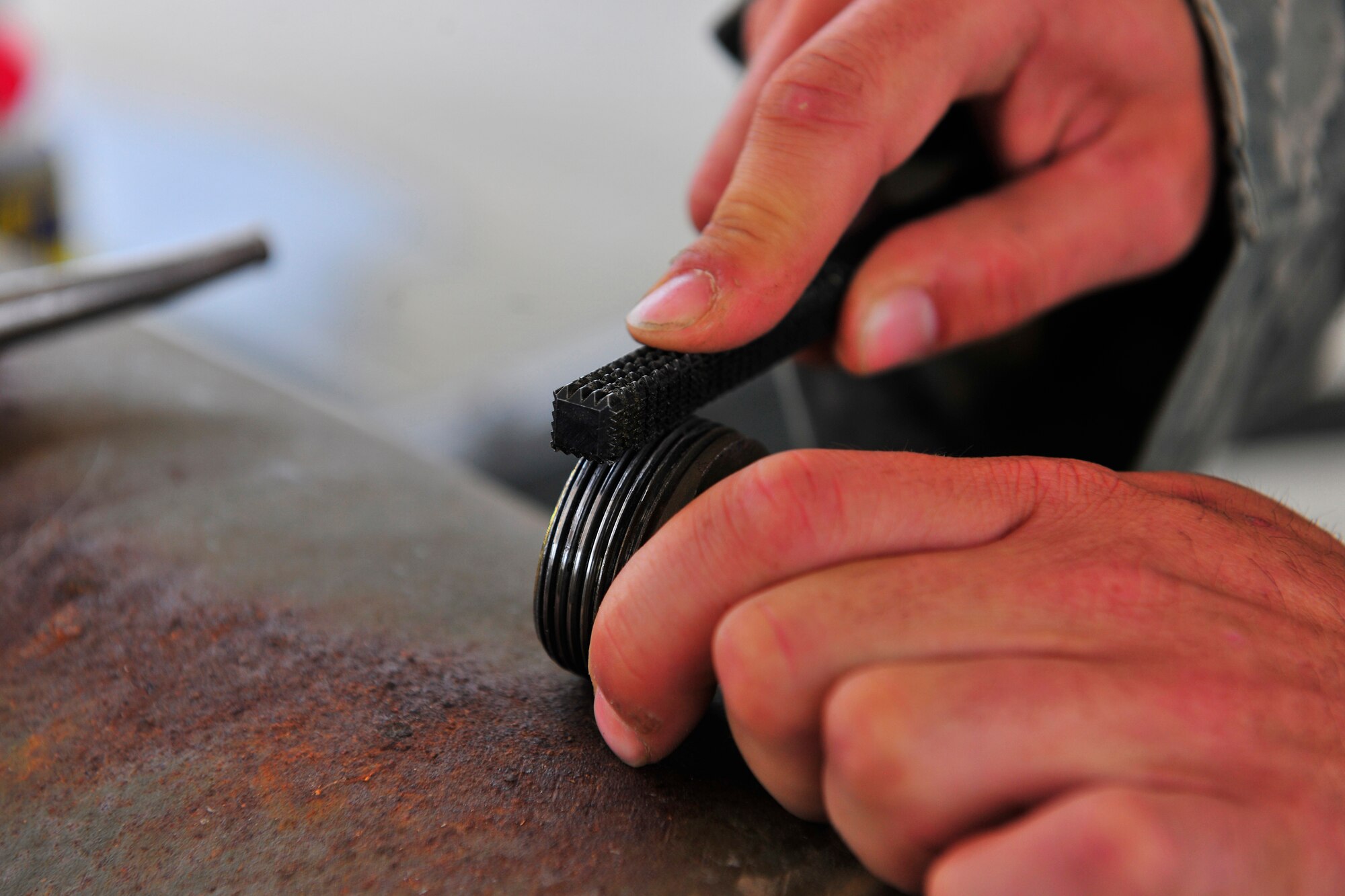 Staff Sgt. Jared Rogers, a munitions systems specialist assigned to the 455th Expeditionary Maintenance Squadron, re-threads a hook designed to fasten the bomb to the aircraft during a bomb build at Bagram Airfield, Afghanistan, July 28, 2010. Sergeant Rogers is a native of Ocean Springs, Miss. (U.S. Air Force photo/Staff Sgt. Christopher Boitz)