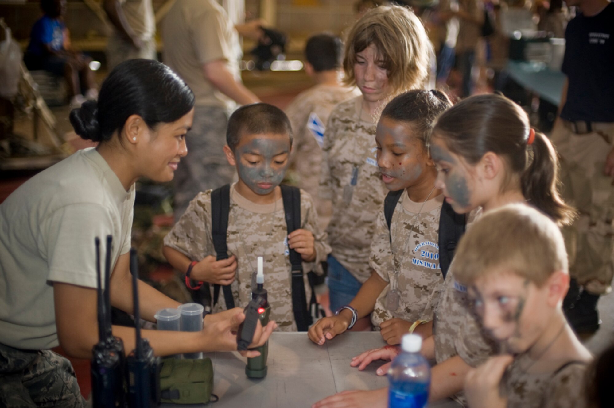 Airman 1st Class Jaimee Topinio, 35th Civil Engineer Squadron emergency management apprentice, shows military children how a joint chemical agent detector works, July 24, during Misawa’s first Operation Children on Deployment Exercise event. Approximately 180 military children, ages 7 to 14, were “recalled” to experience some of the tasks their parents may do during a deployment. (U.S. Air Force photo/ Senior Airman Jessica Lockoski)