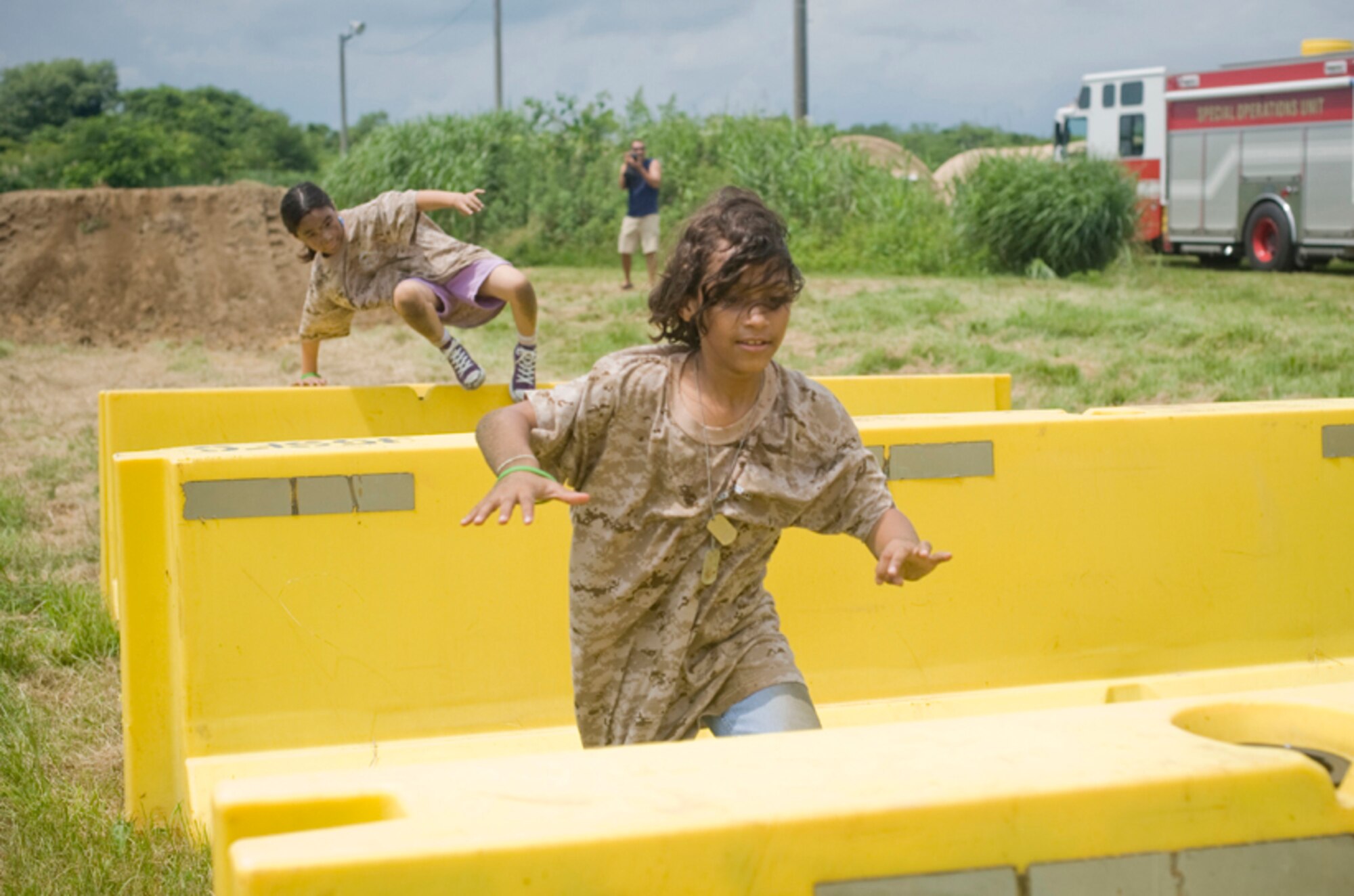 Andrea Hill, 9, daughter of Staff Sgt. Curtis Hill, and Lauren Vicuna, 8, daughter of Master Sgt. Victor Vicuna, jump over barriers in an obstacle course, July 24, during Misawa’s first Operation Children on Deployment Exercise. (U.S. Air Force photo/ Senior Airman Jessica Lockoski)