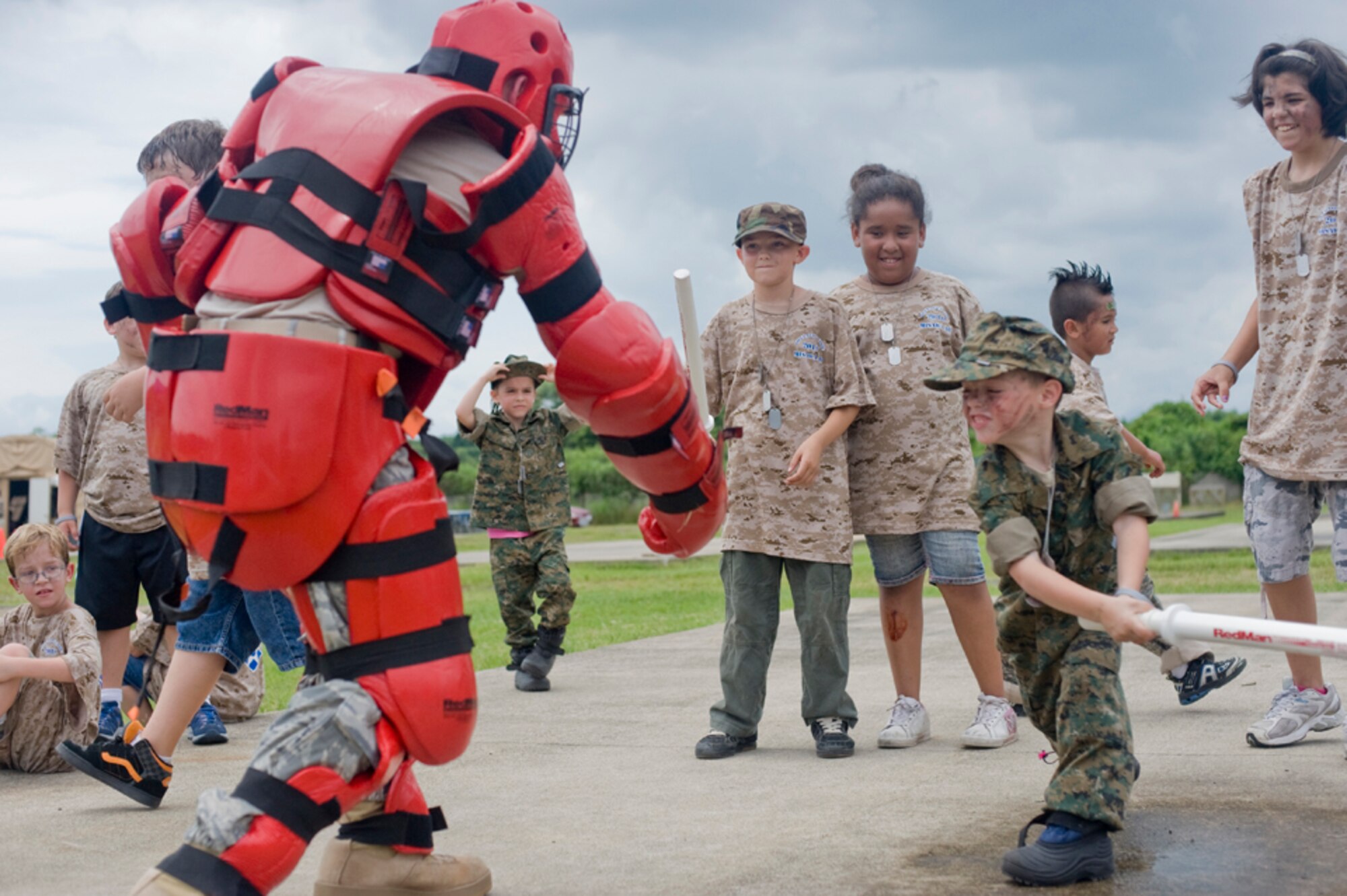 Joseph Lozano, 7, son of Staff Sgt. Rebecca Lozano, swings a baton at Airman 1st Class Jeremy Anderson, 35th Security Forces Squadron, July 24, during Misawa’s first Operation Children on Deployment Exercise.  At Operation CODE, military children “deployed” to Camp Defender and interacted with base security forces, fire department and  explosive ordnance disposal unit and participated in military training activities, showing them what parents may experience while deployed. (U.S. Air Force photo/ Senior Airman Jessica Lockoski)