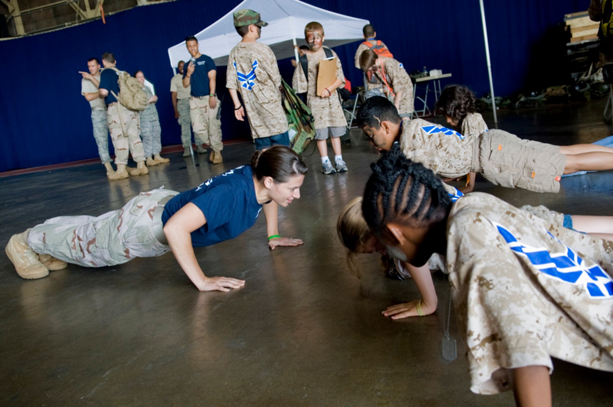 Senior Airman Laura Yager, 35th Civil Engineer Squadron and a military training leader volunteer, challenged military children to perform push-ups, July 24, to show them the importance of physical fitness in the military and while parents are deployed during Misawa’s first Operation Children on Deployment Exercise. Operation CODE allowed children to experience what it’s like for their parents to deploy. (U.S. Air Force photo/ Senior Airman Jessica Lockoski)