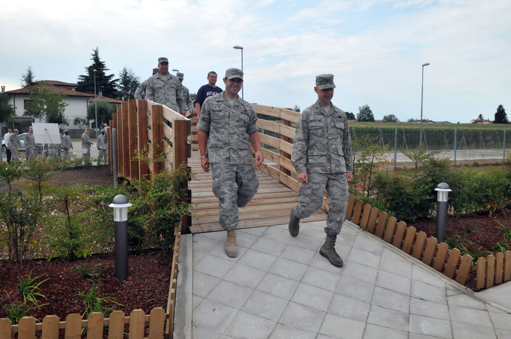 Airmen walk across the new pedestrian bridge after a ribbon-cutting ceremony July 27 at Area 1. The structure connects the parking lot in the upper perimeter with the main Shoppette parking area. (U.S. Air Force photo/Staff Sgt. MercedesKimble Crossland)