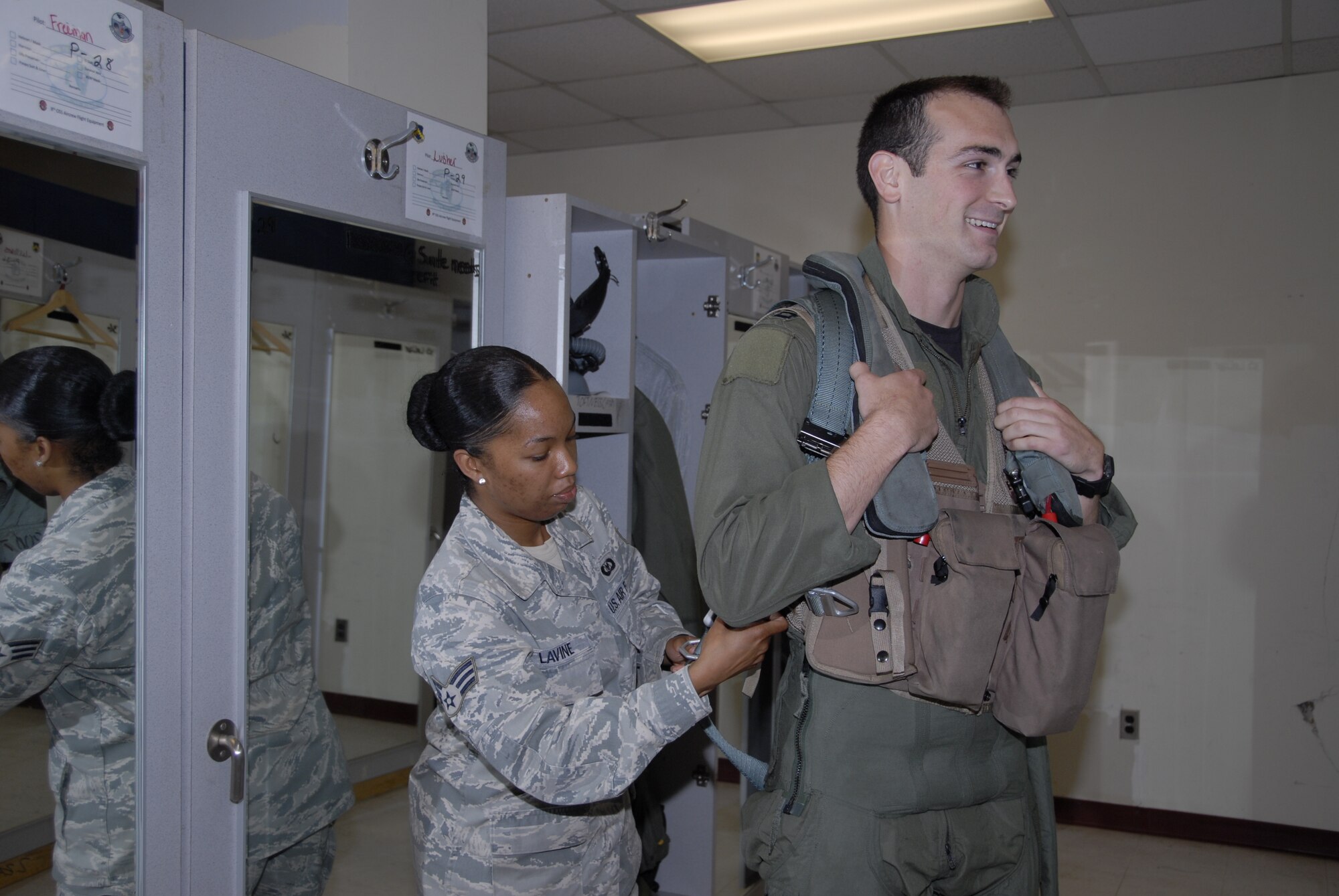KUNSAN AIR BASE, Republic of Korea -- Senior Airman Anisah Lavine, 8th Operations Support Squadron aircrew flight equipment technician, fits a torso harness for Capt. Michael Leary, 35th Fighter Squadron pilot. Members of the 35th and 80th Fighter Squadrons here flew 20 total sorties in support of exercise Invincible Spirit July 25-28, the first in a planned series of Republic of Korea and U.S. Forces Korea combined naval exercises. (U.S. Air Force photo/Staff Sgt. Amanda Savannah)