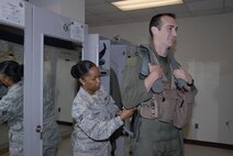 KUNSAN AIR BASE, Republic of Korea -- Senior Airman Anisah Lavine, 8th Operations Support Squadron aircrew flight equipment technician, fits a torso harness for Capt. Michael Leary, 35th Fighter Squadron pilot. Members of the 35th and 80th Fighter Squadrons here flew 20 total sorties in support of exercise Invincible Spirit July 25-28, the first in a planned series of Republic of Korea and U.S. Forces Korea combined naval exercises. (U.S. Air Force photo/Staff Sgt. Amanda Savannah)