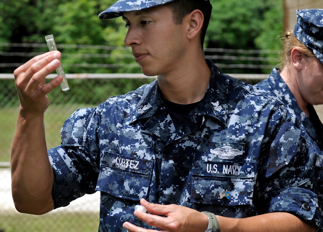 U.S. Navy Petty Officer 1st Class Lee Cortez, assigned to U.S. Naval Hospital Guam, takes water samples at a local well to determine pH levels, Peleliu, Palau, July 27, 2010.