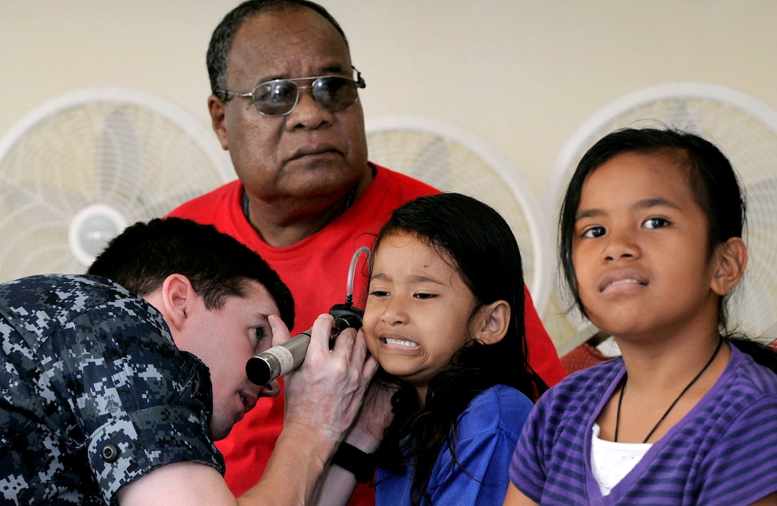 U.S. Navy Lt. Cmdr. David Foster, assigned to Naval Hospital Yokosuka and embarked aboard the USS Blue Ridge, checks a patient's ears at a free medical clinic during a Pacific Partnership 2010 medical civic action program in Koror, Palau, July 27, 2010.