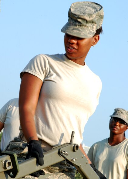 Senior Airman LeKeya Parks, 919th Services Flight, holds a tent center arch in place at Duke Field July 10. The flight set up a Temper tent as part of their annual field training during the July unit training assembly. (U.S. Air Force photo/Tech. Sgt. Cheryl Foster)

