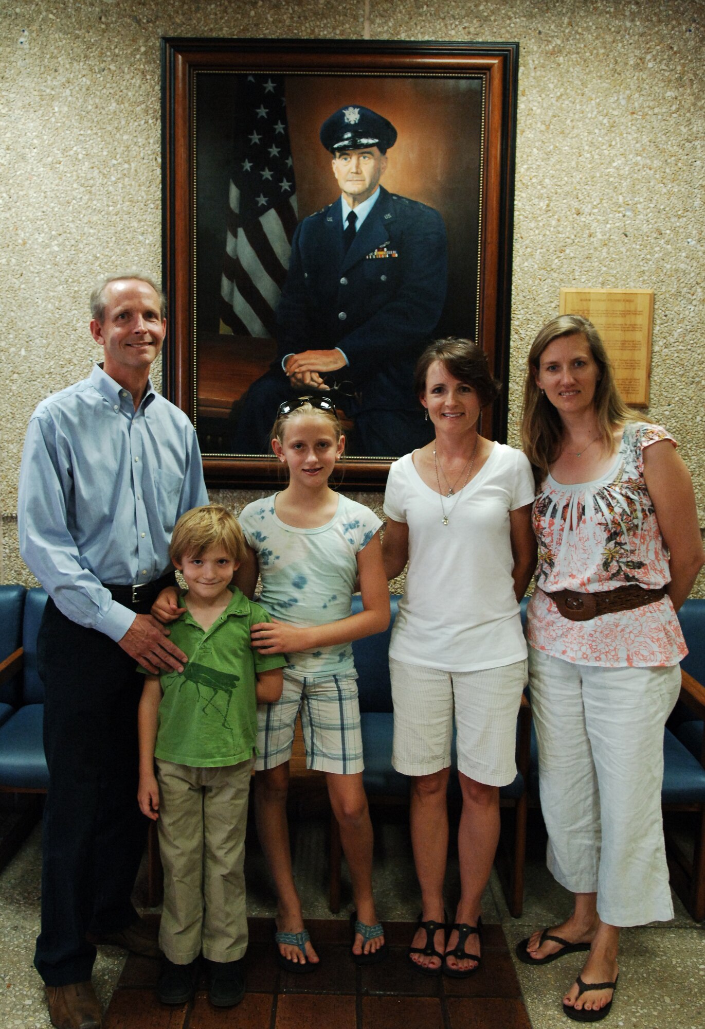 Mr. Jim Hall and his wife, Kendra (right), pose in front of a painting of Maj. Gen. (Dr.) Wilford Hall at the medical center?s main entrance July 30. Mr. Hall, General Hall's great nephew and his sister, Susan Hall Johnson, General Hall's great niece (second from right), visited the hospital along with his son, Charlie, and daughter, Allie, meeting Maj. Gen. Tom Travis, 59th Medical Wing commander, and touring the simulation center, obstetrics ward, and neonatal intensive care unit. The Hall family, visiting San Antonio from Charlottesville, Va., had never been to the medical center before. (U.S. Air Force photo by Tech. Sgt. Andy Bellamy)