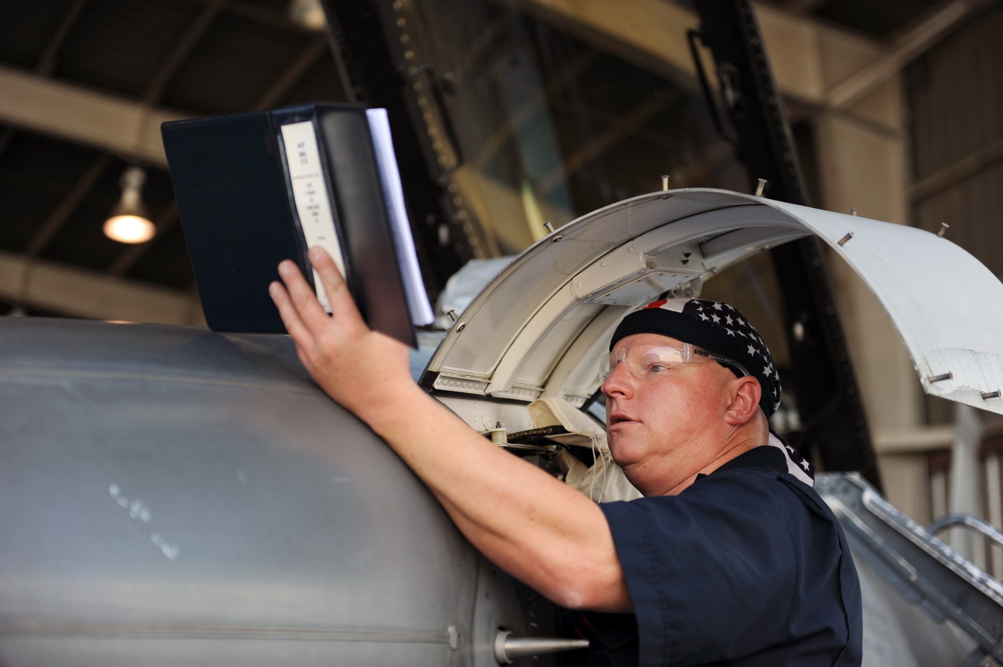 Kris Clark checks a technical manual as he replaces a gyro on an F-16 Fighting Falcon July 30, 2010, at Davis-Monthan Air Force Base, Ariz.  F-16s are being converted into usable manned or drone targets allowing Airmen to train and test new weapons platforms.  Mr. Clark is an aircraft mechanic for the 309th Aerospace Maintenance and Regeneration Group. (U.S. Air Force photo/Staff Sgt. Desiree N. Palacios)